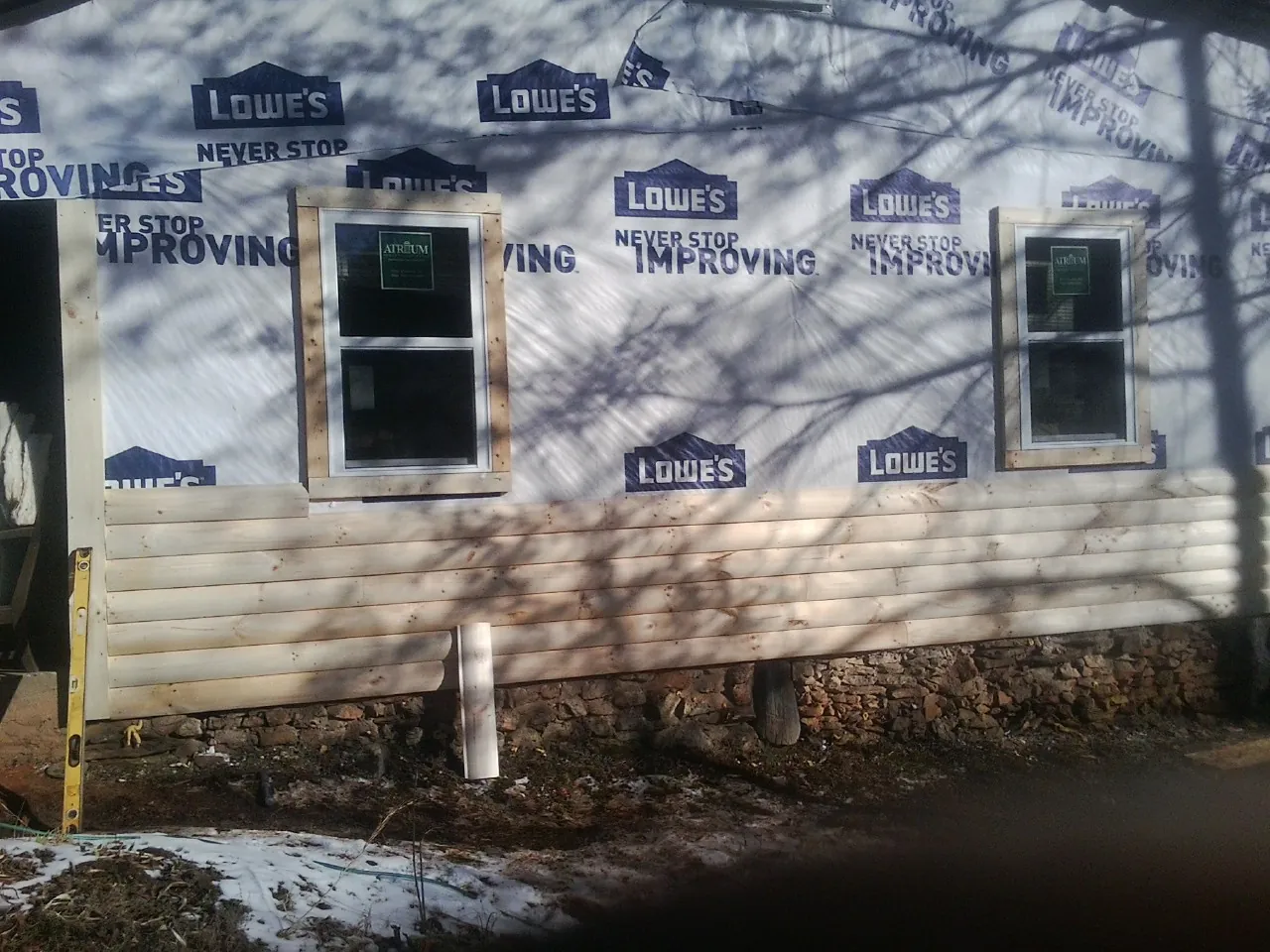 House wrap and new log siding going up on an exterior wall in Council Bluffs