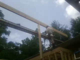 Carpenter setting a ridge beam over a new addition frame — Ice Dam Removal by Roofing Brothers in Council Bluffs