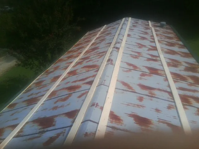 Rusted metal roof panels with new wood purlins before replacement — Storm Damage Roof Repair in Council Bluffs by Roofing Brothers