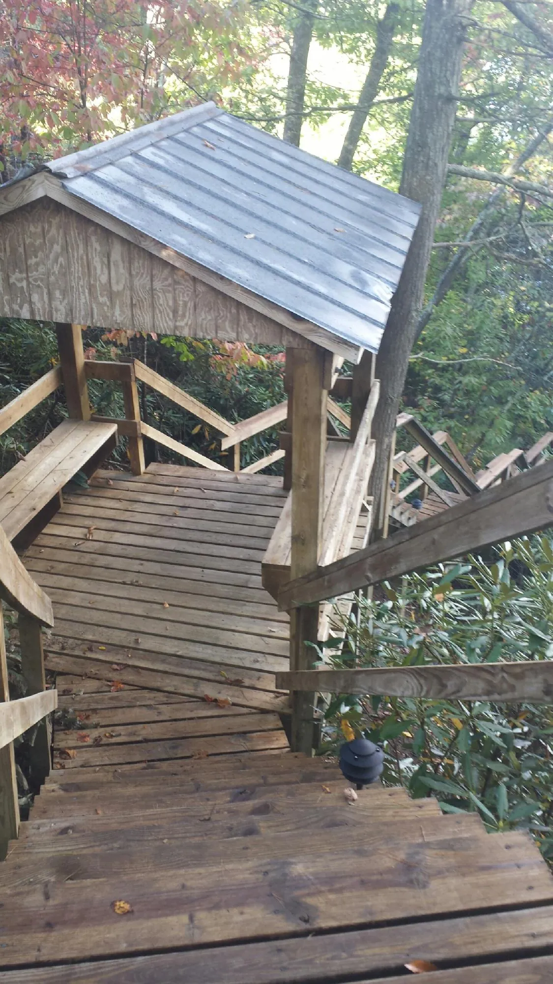 Metal roofed shelter over wooden steps on a wooded walkway — Skylight Repair & Installation work by our crew in Council Bluffs
